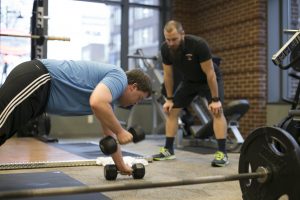 man working out while being coached